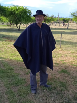 Poncho Criollo Con Guarda Pampeana - Poncho de paño liso con sesgo en cuello, guarda pampa fina en delantera y espalda y dobladillo en bordes.